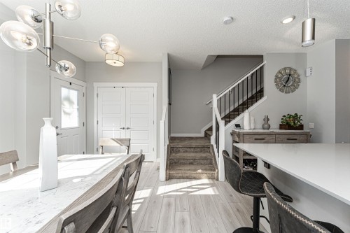 Dining area with light wood-type flooring and a textured ceiling - 16616 31 Avenue, Edmonton, AB - Indoor Photo Showing Kitchen