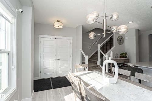 Dining space featuring a textured ceiling, a chandelier, and light wood-style floors - 16616 31 Avenue, Edmonton, AB - Indoor Photo Showing Other Room