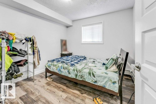 Bedroom featuring a textured ceiling and light wood-style flooring - 101 400 Silver Berry Road, Edmonton, AB - Indoor Photo Showing Bedroom