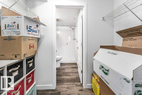 Bathroom with a textured ceiling, a walk in shower, and dark wood-style floors - 101 400 Silver Berry Road, Edmonton, AB - Indoor