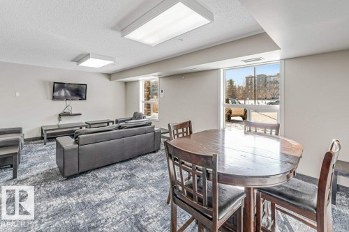 Carpeted dining room featuring a textured ceiling - 101 400 Silver Berry Road, Edmonton, AB - Indoor Photo Showing Dining Room