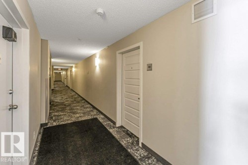 Hall with a textured ceiling - 101 400 Silver Berry Road, Edmonton, AB - Indoor Photo Showing Other Room