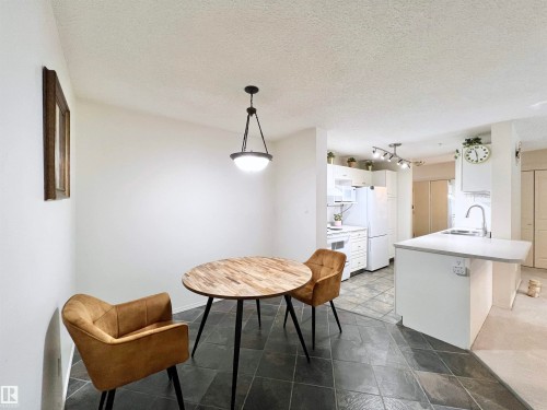 Dining area with a textured ceiling - 110 10511 42 Avenue, Edmonton, AB - Indoor