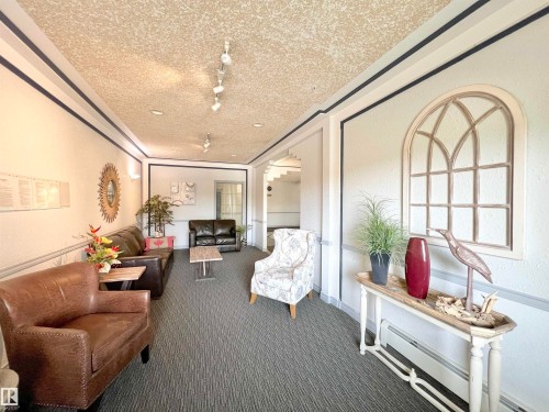 Common area featuring a textured wall and a textured ceiling - 110 10511 42 Avenue, Edmonton, AB - Indoor