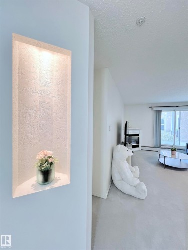 Hallway with carpet floors and a baseboard radiator - 110 10511 42 Avenue, Edmonton, AB - Indoor Photo Showing Other Room