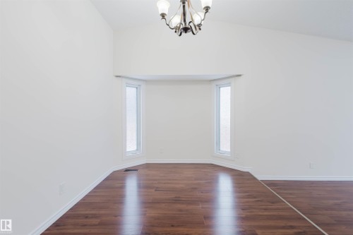 Unfurnished room featuring hanging lights, dark wood finished floors, and plenty of natural light - 243 Rhatigan Road E, Edmonton, AB - Indoor Photo Showing Other Room