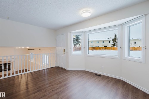 Spare room featuring a textured ceiling and dark wood-type flooring - 243 Rhatigan Road E, Edmonton, AB - Indoor Photo Showing Other Room