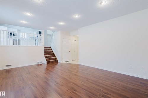 Unfurnished room with dark wood-style floors, a textured ceiling, and recessed lighting - 243 Rhatigan Road E, Edmonton, AB - Indoor Photo Showing Other Room