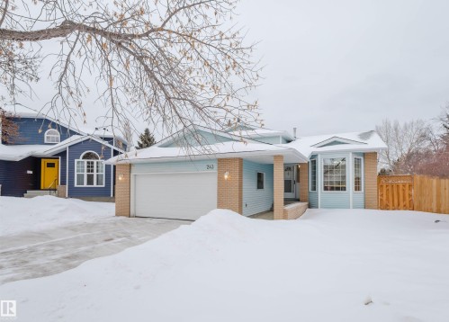 View of front of house featuring brick siding, an attached garage, and driveway - 243 Rhatigan Road E, Edmonton, AB - Outdoor With Facade