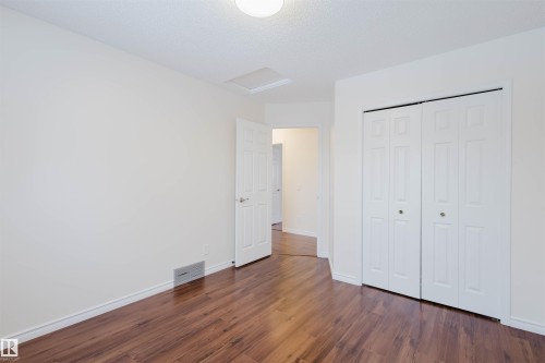 Unfurnished bedroom with dark wood-style floors, a closet, and a textured ceiling - 243 Rhatigan Road E, Edmonton, AB - Indoor Photo Showing Other Room