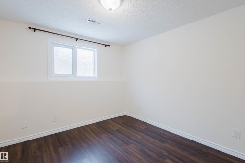 Unfurnished room with dark wood finished floors and a textured ceiling - 243 Rhatigan Road E, Edmonton, AB - Indoor Photo Showing Other Room