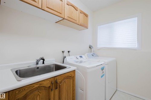 Laundry area with cabinet space and washer and dryer - 243 Rhatigan Road E, Edmonton, AB - Indoor Photo Showing Laundry Room