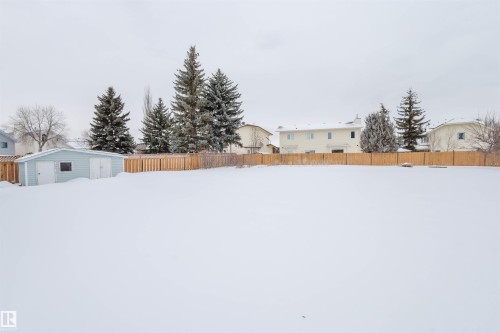 Snowy yard featuring a fenced backyard and an outdoor structure - 243 Rhatigan Road E, Edmonton, AB - Outdoor