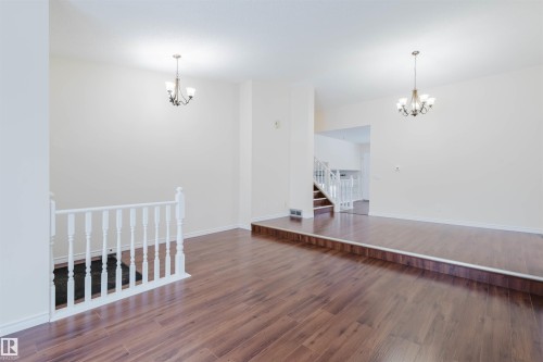 Spare room with suspended lighting and dark wood-style floors - 243 Rhatigan Road E, Edmonton, AB - Indoor Photo Showing Other Room
