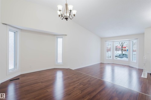 Unfurnished room featuring lofted ceiling, dark wood-type flooring, and suspended lighting - 243 Rhatigan Road E, Edmonton, AB - Indoor Photo Showing Other Room