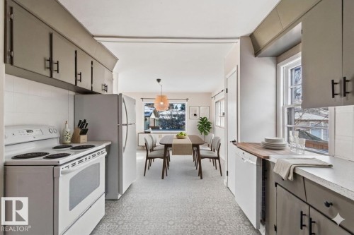 Kitchen with white appliances, light countertops, hanging light fixtures, and decorative backsplash - 12225 134 Street, Edmonton, AB - Indoor Photo Showing Kitchen