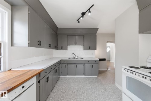 Kitchen with gray cabinets, white appliances, arched walkways, rail lighting, and wood counters - 12225 134 Street, Edmonton, AB - Indoor Photo Showing Kitchen With Double Sink