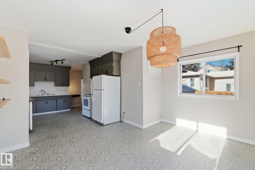 Kitchen featuring white appliances, backsplash, light floors, and hanging light fixtures - 12225 134 Street, Edmonton, AB - Indoor Photo Showing Other Room
