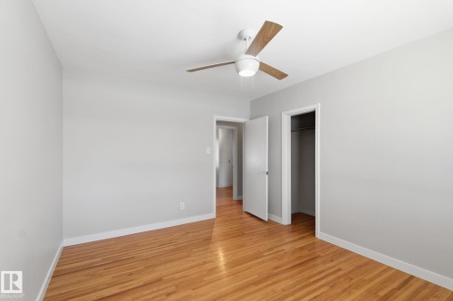 Unfurnished bedroom featuring a spacious closet, light wood-style floors, and a ceiling fan - 12225 134 Street, Edmonton, AB - Indoor Photo Showing Other Room