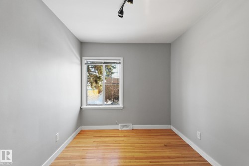 Spare room featuring light wood finished floors and track lighting - 12225 134 Street, Edmonton, AB - Indoor Photo Showing Other Room