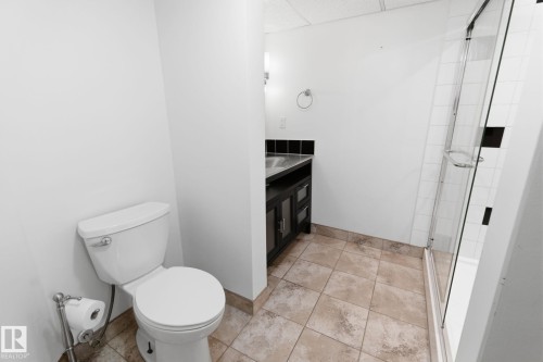 Full bathroom featuring a drop ceiling, a stall shower, vanity, and light tile patterned floors - 12225 134 Street, Edmonton, AB - Indoor Photo Showing Bathroom