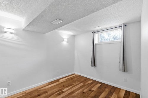 Spare room featuring wood finished floors and a textured ceiling - 12225 134 Street, Edmonton, AB - Indoor Photo Showing Other Room