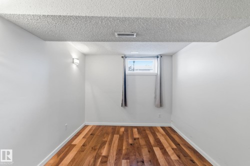 Unfurnished room with wood finished floors and a textured ceiling - 12225 134 Street, Edmonton, AB - Indoor Photo Showing Other Room
