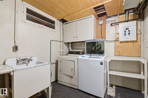 Laundry room with cabinet space, electric panel, and washing machine and clothes dryer - 12225 134 Street, Edmonton, AB - Indoor Photo Showing Laundry Room