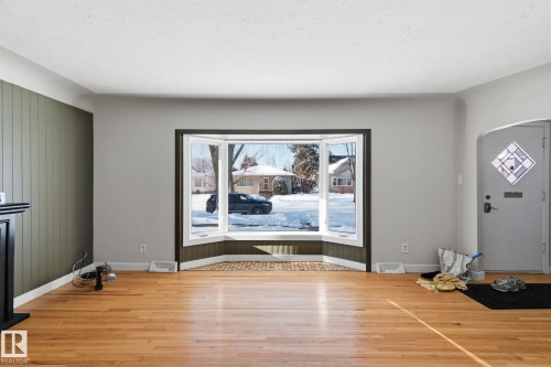 Foyer featuring arched walkways, light wood-type flooring, and wooden walls - 12225 134 Street, Edmonton, AB - Indoor