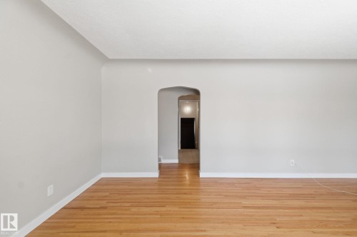 Unfurnished room featuring arched walkways and light wood-style floors - 12225 134 Street, Edmonton, AB - Indoor Photo Showing Other Room
