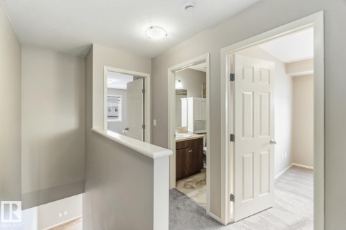 Corridor with light colored carpet and baseboards - 16 3751 12 Street, Edmonton, AB - Indoor Photo Showing Other Room