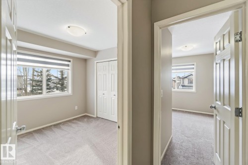 Hall with light carpet and healthy amount of natural light - 16 3751 12 Street, Edmonton, AB - Indoor Photo Showing Other Room