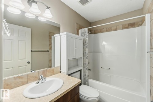 Bathroom with vanity and shower / bath combo with shower curtain - 16 3751 12 Street, Edmonton, AB - Indoor Photo Showing Bathroom