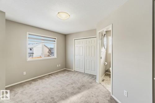 Unfurnished bedroom with light colored carpet, a closet, and a textured ceiling - 16 3751 12 Street, Edmonton, AB - Indoor Photo Showing Other Room
