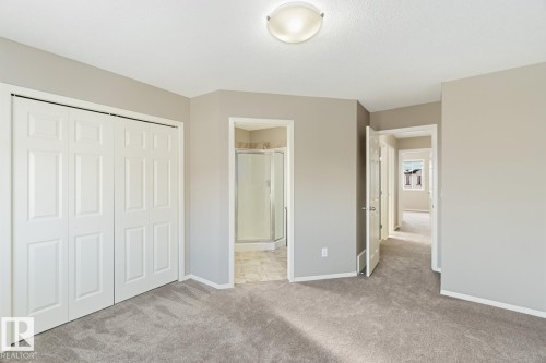Unfurnished bedroom featuring a closet, light carpet, and ensuite bath - 16 3751 12 Street, Edmonton, AB - Indoor