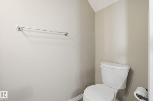 Bathroom with toilet and a textured ceiling - 71 4029 Orchards Drive, Edmonton, AB - Indoor Photo Showing Bathroom