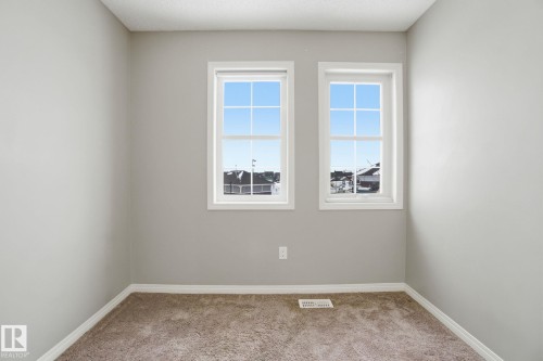 Unfurnished room featuring light carpet and baseboards - 71 4029 Orchards Drive, Edmonton, AB - Indoor Photo Showing Other Room