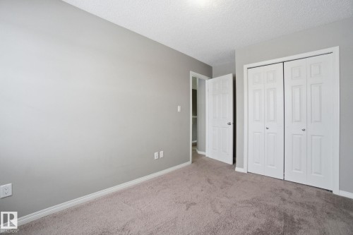 Unfurnished bedroom featuring carpet, a closet, and a textured ceiling - 71 4029 Orchards Drive, Edmonton, AB - Indoor