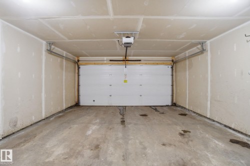 Garage featuring a garage door opener - 71 4029 Orchards Drive, Edmonton, AB - Indoor Photo Showing Garage