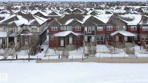 Craftsman-style house featuring a fenced front yard and a residential view - 71 4029 Orchards Drive, Edmonton, AB - Outdoor With Facade