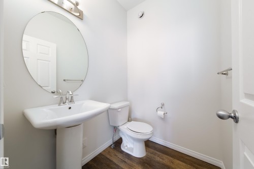 Bathroom with toilet and dark wood-type flooring - 1199 Watt Drive, Edmonton, AB - Indoor Photo Showing Bathroom