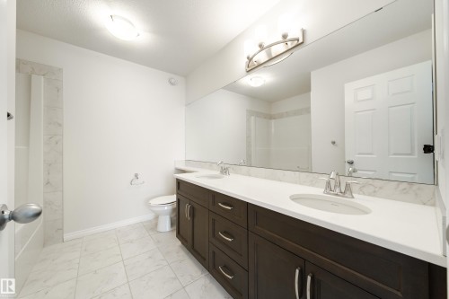 Bathroom with double vanity, light marble finish flooring, and a shower - 1199 Watt Drive, Edmonton, AB - Indoor Photo Showing Bathroom