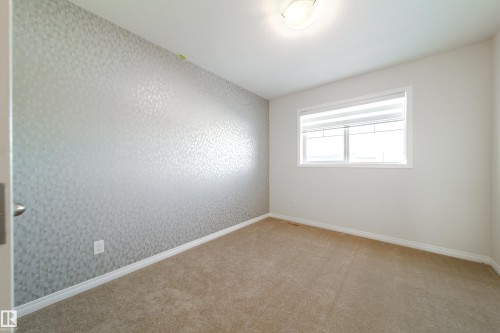 Empty room with light carpet and wallpapered walls - 1199 Watt Drive, Edmonton, AB - Indoor Photo Showing Other Room