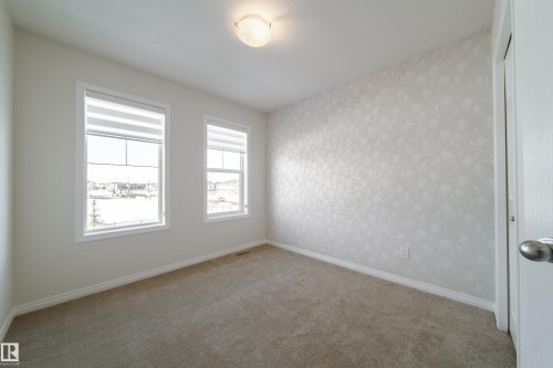 Unfurnished room featuring light carpet and wallpapered walls - 1199 Watt Drive, Edmonton, AB - Indoor Photo Showing Other Room