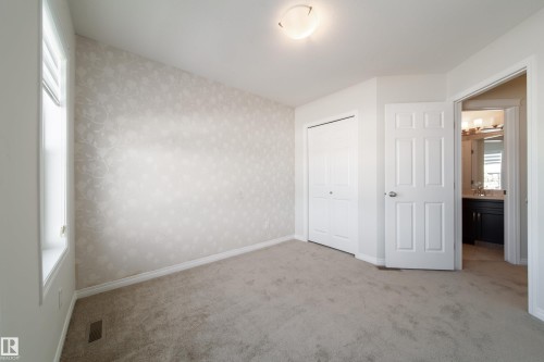 Unfurnished bedroom featuring light colored carpet, a closet, and wallpapered walls - 1199 Watt Drive, Edmonton, AB - Indoor Photo Showing Other Room