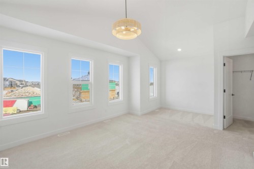 Unfurnished bedroom featuring vaulted ceiling, light colored carpet, a spacious closet, and recessed lighting - 6949 176A Avenue, Edmonton, AB - Indoor Photo Showing Other Room