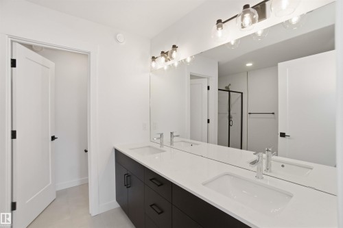 Full bathroom with a shower stall, double vanity, and light tile patterned floors - 6949 176A Avenue, Edmonton, AB - Indoor Photo Showing Bathroom