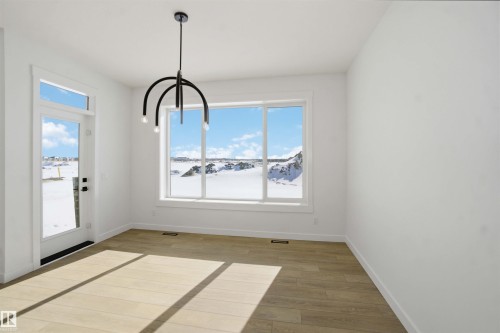 Unfurnished dining area featuring baseboards and light wood-type flooring - 6949 176A Avenue, Edmonton, AB - Indoor Photo Showing Other Room