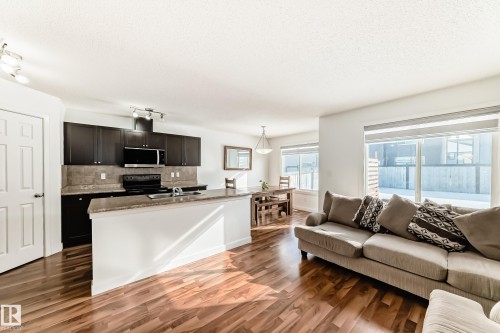 Living area with dark wood-style flooring and a textured ceiling - 17357 8A Avenue, Edmonton, AB 