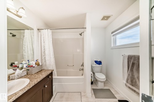 Bathroom featuring vanity and shower / bathtub combination with curtain - 17357 8A Avenue, Edmonton, AB 